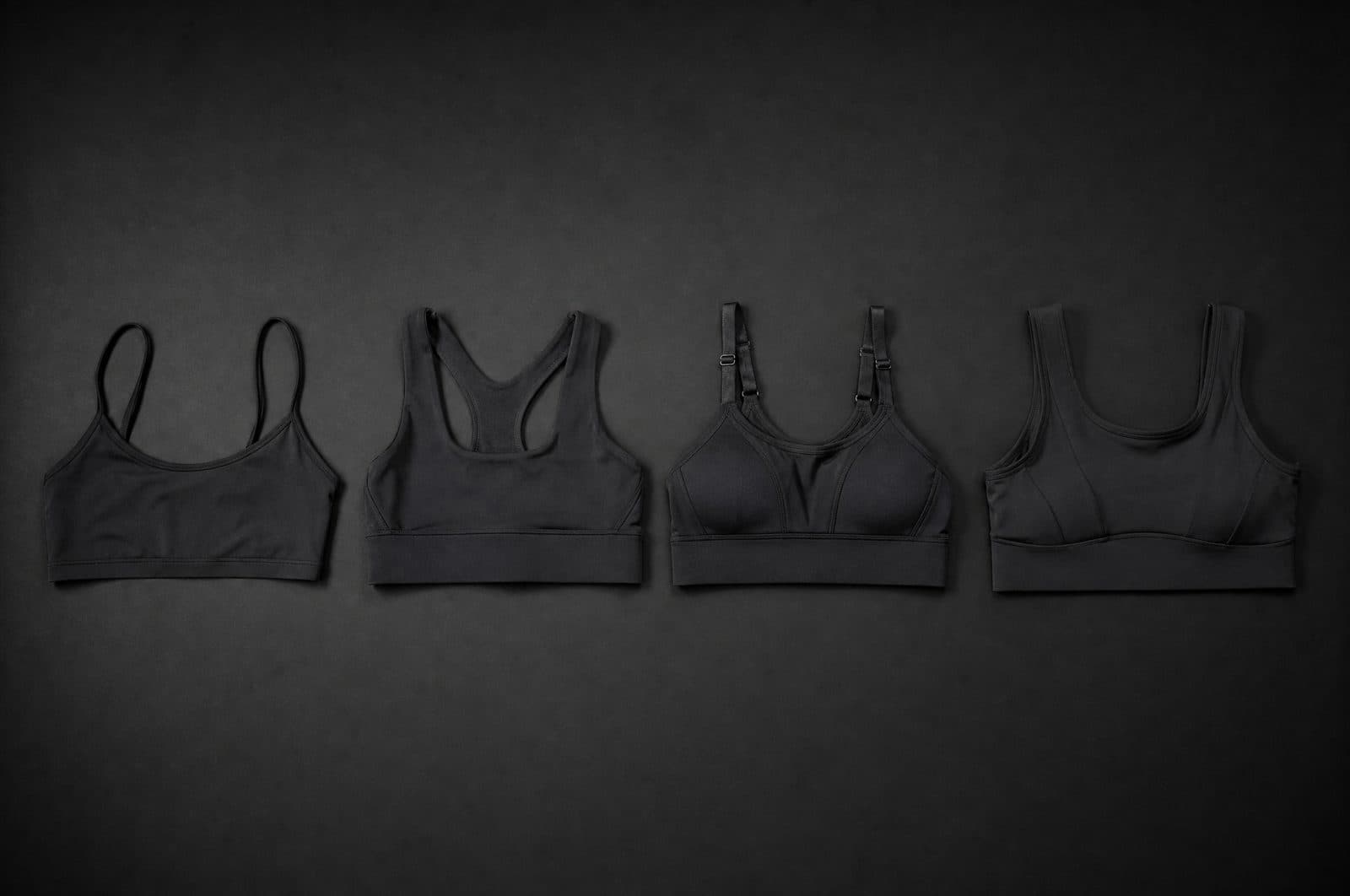 Four sports bras laid flat in a row, increasing in band width and strap width from left to right